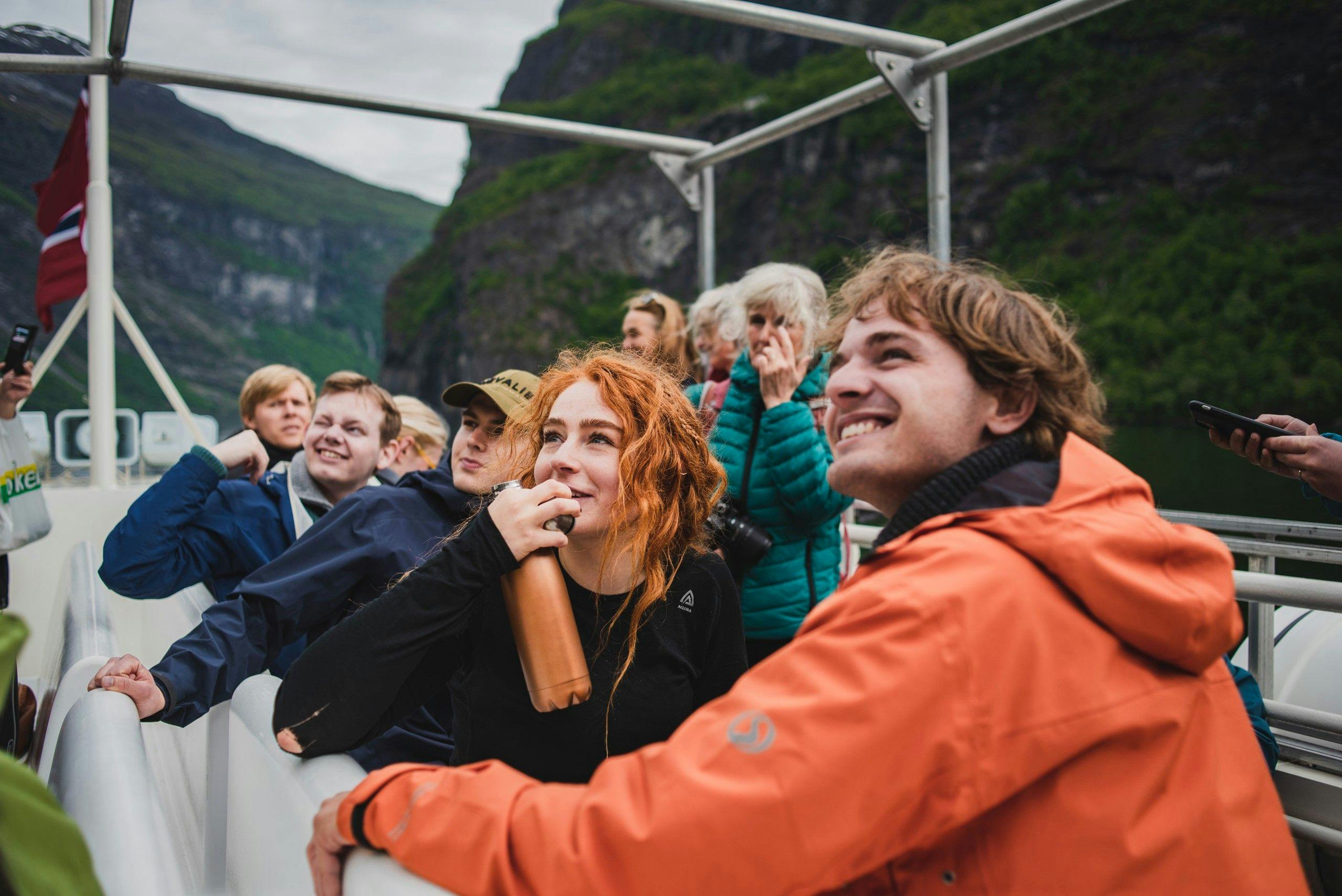 Smilende mennesker ombord i båt. 